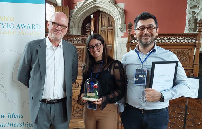 Three people standing and holding awards