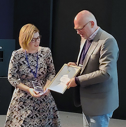 A man and a woman holding a framed certificate