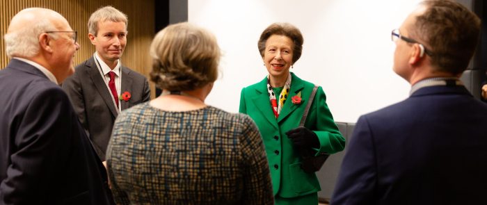 A woman in green suit meeting people