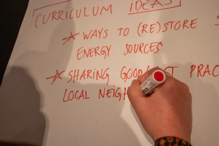 Image of a person writing down curriculum ideas about green transition on a flipchart