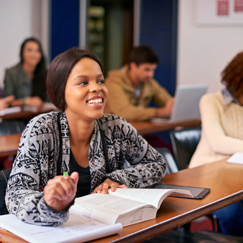 SMALEI Webinar 3: Engagement of learners - a woman in a classroom with an open book smiling