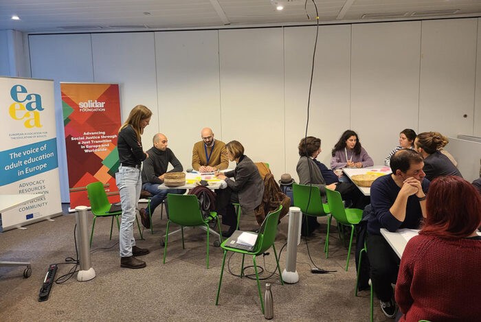 people in classroom, sitting around tables