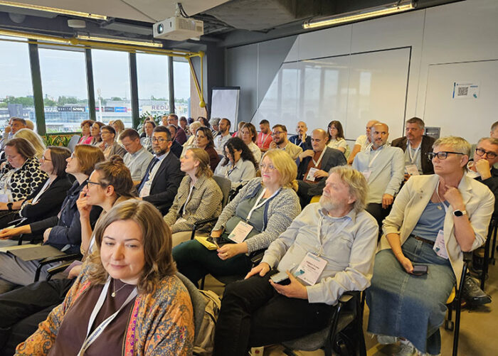 people in a conference room, listening to the speaker